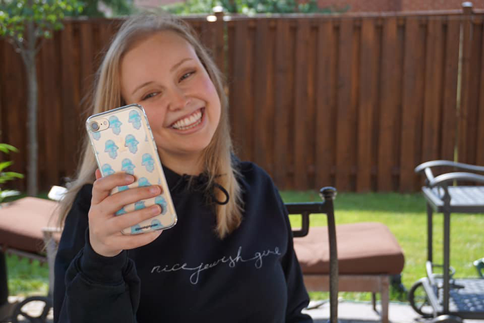 Aly Silverberg, creator of @JewishGirlProbs, looking at her phone
